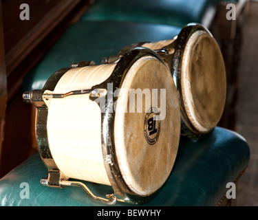 Tambores Bongo sentado en un taburete de piano Foto de stock