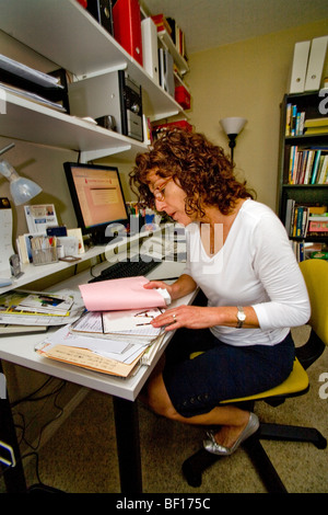 A los 50 años una mujer autónomos trabaja en su oficina principal en Mission Viejo, California. Foto de stock