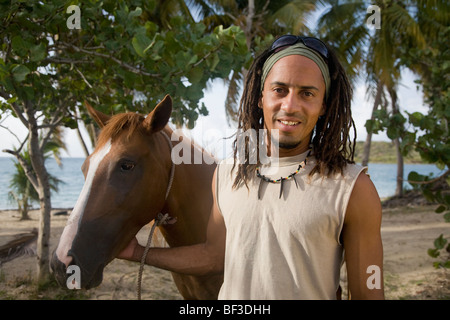 Hombre hispano líder en caballo cerca de la playa