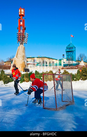 Los hombres jóvenes jugar hockey sobre hielo en el Assiniboine River, en las horquillas, Winnipeg, Manitoba, Canadá Foto de stock