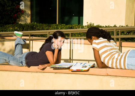 La gente joven de 13 a 14 años de bloqueo colgando afroamericanos e hispanos Dos niñas estudian juntos en el exterior. California señor © Myrleen Pearson Foto de stock