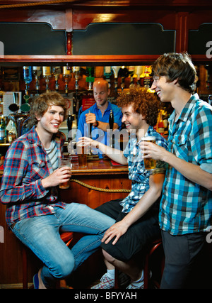 Los hombres jóvenes bebiendo en el bar Foto de stock