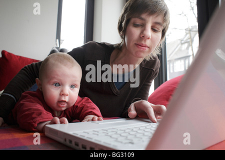 La madre y el niño trabaja en un portátil.