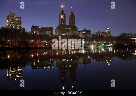 Las torres de San Remo, Central Park West skyline en la noche reflejada en el lago, Central Park, Manhattan, Ciudad de Nueva York, EE.UU.