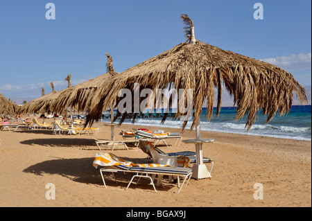 Sillas de playa, bajo el paraguas de paja soleada "Mar Rojo" Foto de stock