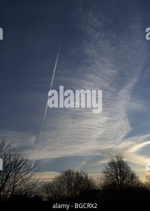 Los pájaros, las estelas de condensación y nubes cirrus en Swindon street Foto de stock