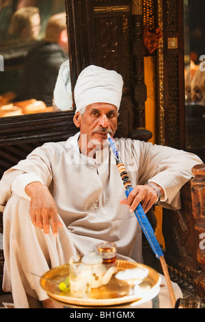 Fumar un hombre maduro en el Cafe Fishawi waterpipe en Bazar Khan el-Khalili, en El Cairo, Egipto, África Foto de stock
