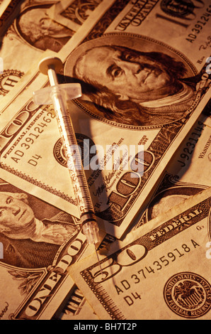 Jeringa en dinero americano Foto de stock
