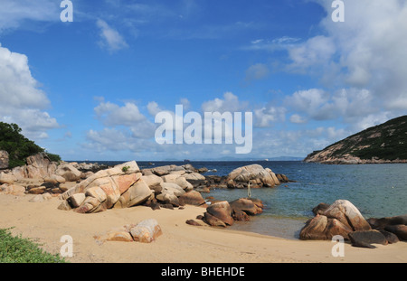 Cielo azul, mar azul, rocas de granito vista a la playa, en una bahía en el borde del mar del Sur de China, cerca de Tun O, la isla de Lamma, Hong Kong Foto de stock