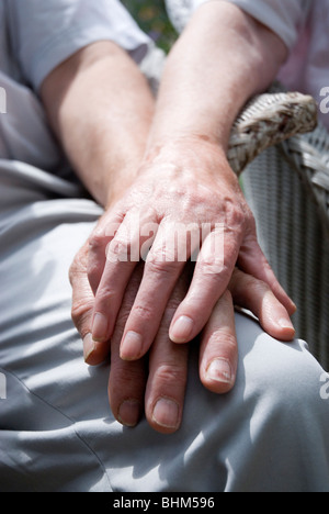 Imagen recortada de la pareja de ancianos cogidos de la mano.