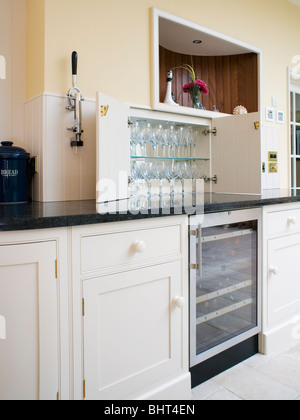 Copas de vino en los estantes en la despensa de cocina encima de wine cooler refrigerado