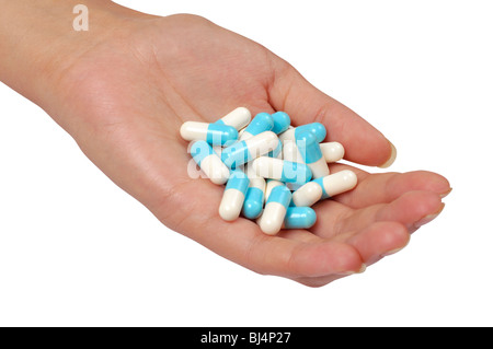Una mano llena de cápsulas de medicamento aislado sobre fondo blanco. Foto de stock