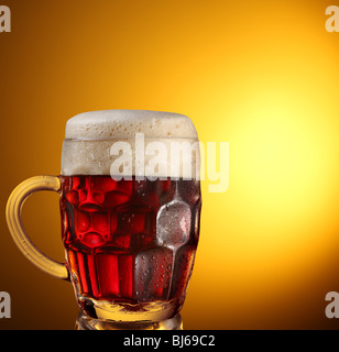 Vaso de cerveza oscura sobre un fondo marrón