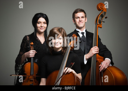 Retrato de estudio de tres músicos jóvenes con instrumentos