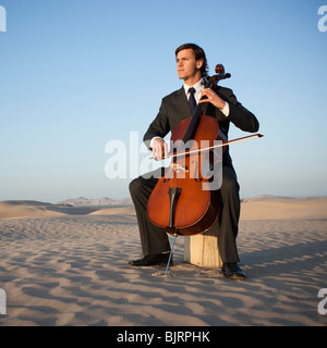 Estados Unidos, Utah, pequeño Sáhara, joven con chelo en el desierto Foto de stock