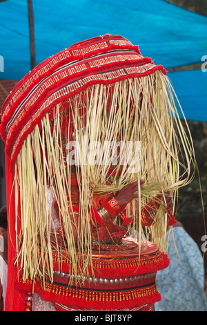 India, Kerala, Kannur (Cannanore), Theyyam, deidad serpiente Naga Kanni cubiertos con palm fronda tocado Foto de stock