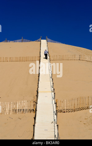 Hombre subiendo escalones que conducen a las dunas du Pyla, la bahía de Arcachon, Cote d'Argent, Aquitania, Francia, Europa Foto de stock