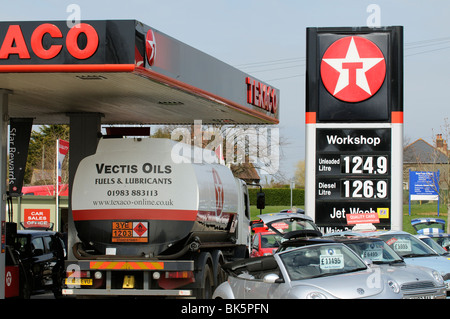 Signo de alto precio del combustible fuera de una estación de gasolina en Newport Isle of Wight Southern England Reino Unido petrolero camión haciendo una entrega Foto de stock