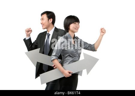 Joven Empresaria y el empresario sosteniendo flechas