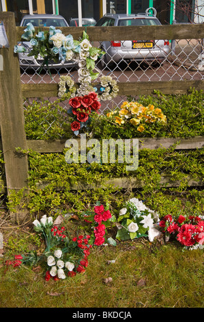 Memorial en la carretera en la escena del accidente fatal racimos de flores de plástico atado a la valla Abertillery Blaenau Gwent South Wales UK Foto de stock