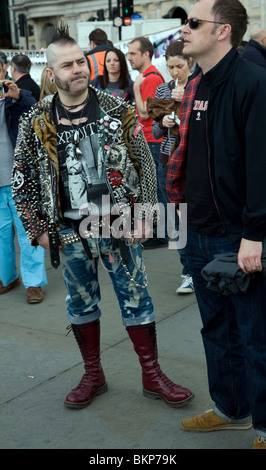 Hombre vestido con ropa Punk Rocker con pelo de punta y una guitarra posan  para fotos turísticas en Camden High Street, Camden, Londres, Reino Unido  Fotografía de stock - Alamy