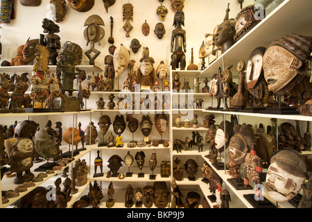 Máscaras de madera y recuerdos a la venta en una calle larga tienda de curiosidades en Cape Town.