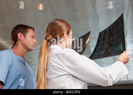 Médico y un enfermero de examinar un informe de exploración de RM Foto de stock