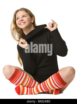 Hermosa niña en marrón suéter y en rayas calcetines largos sentarse en el piso, en blanco Fotografía de stock - Alamy