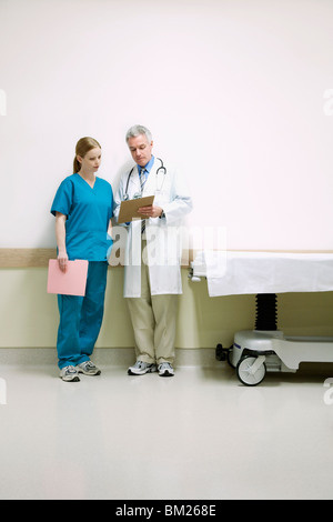 Los médicos analizando un informe médico con un enfermero. Foto de stock