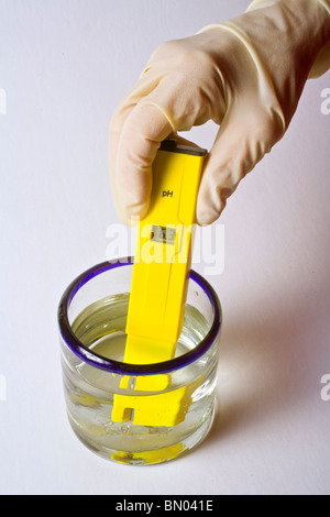 Un medidor de pH digital se utiliza para controlar la acidez o la alcalinidad de una muestra de líquido, mostrando un alto nivel de ácido. Foto de stock