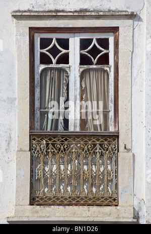 Ventana pintada en blanco rústico del Viejo Mundo en Europa, con balcón de hierro forjado. Foto de stock