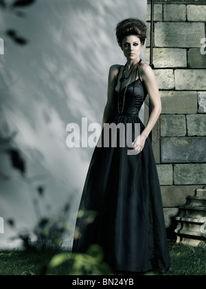 Licencia disponible en MaximImages.com Foto de alta moda de una hermosa mujer con vestido largo negro Foto de stock