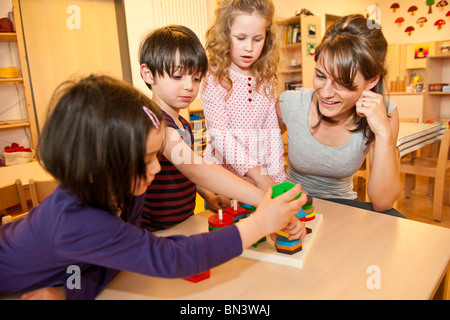Maestra de kindergarten niños jugando Foto de stock