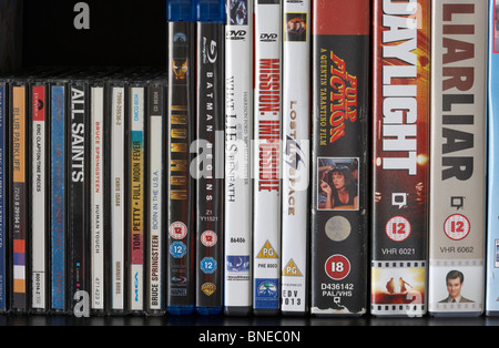 Fila de DVD Blu-ray video vhs casos y discos CD en un estante en el reino unido Foto de stock
