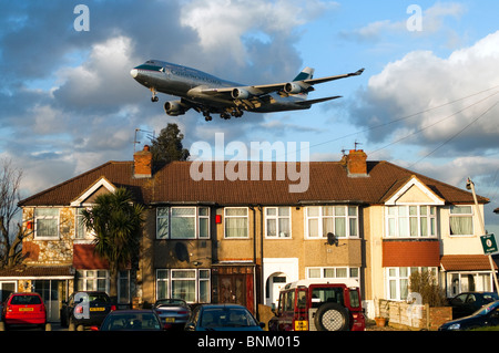 Enfoque la pista de Heathrow por Boeing 747, Cathay Pacific Cargo, aterrizando en el aeropuerto de Heathrow en Londres, Reino Unido. Myrtle Avenue casas en de primer plano. Foto de stock