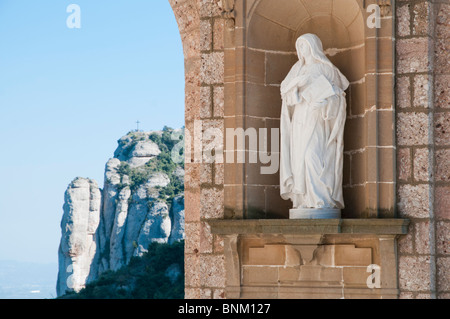 Estatua católica de pertinencia de personas en la explanada principal del santuario de Montserrat, centro religioso de Cataluña, España Foto de stock