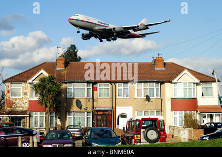 Pista de Heathrow acercamiento por Boeing 747, Malaysia Airlines, el enfoque sobre las casas bajas para aterrizar en el aeropuerto de Heathrow en Londres, Myrtle Avenue, en el Reino Unido. Foto de stock
