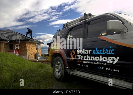 Comerciante cualificado instalación de sistema solar de agua caliente de una casa, Nelson, Nueva Zelanda, la ciudad con mayor número de horas de sol Foto de stock