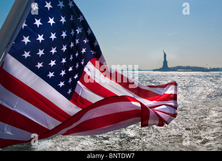 La bandera americana el Stars & Stripes, con la estatua de la libertad en el fondo, Nueva York, Estados Unidos. América Foto de stock