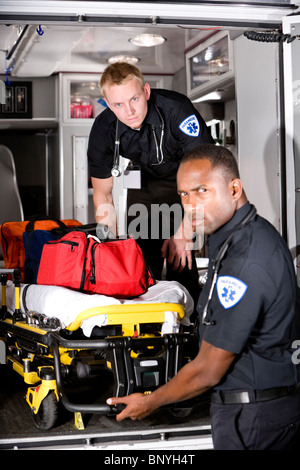 Los paramédicos multirracial teniendo camilla de ambulancia Foto de stock