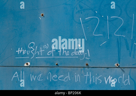 Graffiti en una pared azul sugiriendo pensamiento del día. Foto de stock