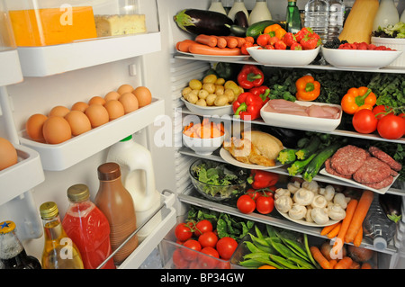 Vista interior de la nevera con estantes llenos de alimentos frescos Foto de stock