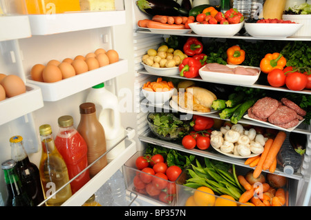 Vista interior de la nevera con estantes llenos de alimentos frescos Foto de stock