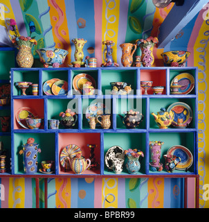 Close-up de estantes azules con una colección de colorida Cerámica jarras y platos por jóvenes Mary-Rose