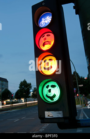 Ciclo de rostros dibujados en los semáforos al atardecer en Berlín, Alemania Foto de stock