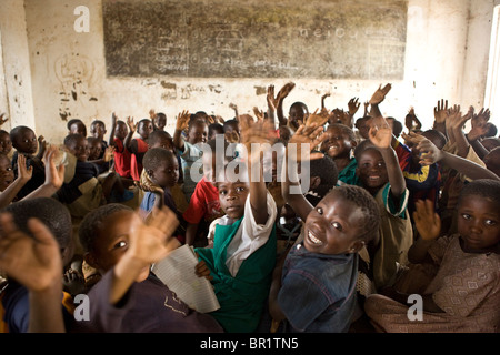 Niños sentados en el piso de una concurrida aula en la región central de Malawi. Foto de stock