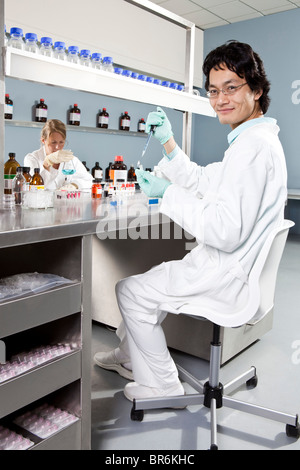 Dos técnicos de laboratorio que trabajan en un laboratorio, se centran en el hombre en primer plano