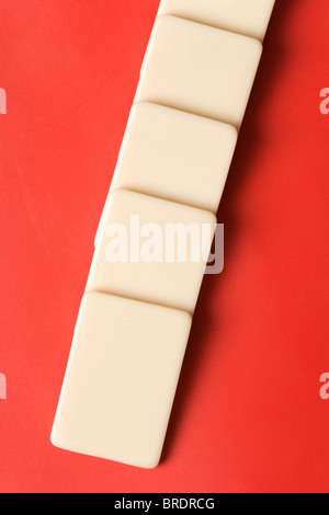Domino con fondo rojo, el concepto de causa o de trabajo en equipo Foto de stock