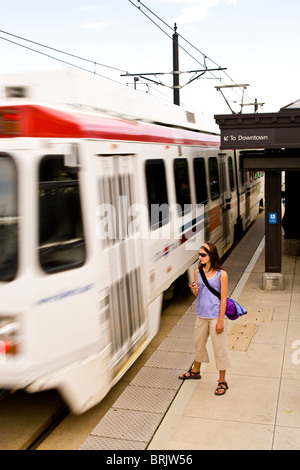 Una joven mujer escucha a su reproductor MP3 mientras espera su tren en Salt Lake City, Utah.