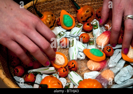 Halloween una canasta llena de dulces, chocolates, etc como ofrendas a niños y personas disfrazadas que llaman a la puerta Foto de stock